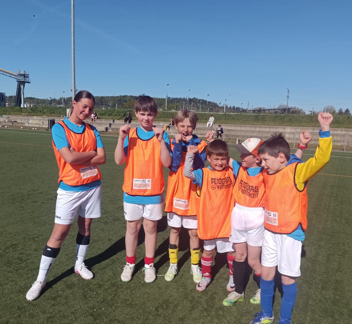 Kleines Team in orangen Leibchen jubelt nach dem Spiel