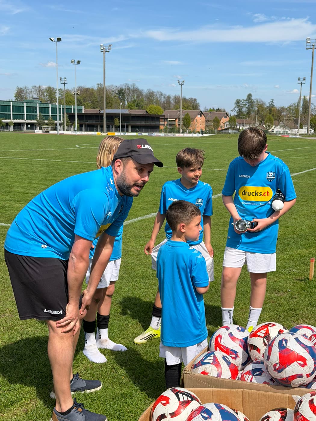 Coach im Gespräch mit Kindern an der Ballbox